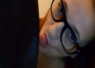 戴眼鏡的戀獸癖者正在吸吮一隻黑狗多汁的陰莖